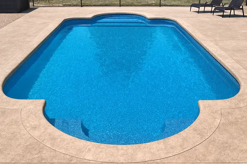 A Roman-style inground swimming pool with crystal-clear blue water, featuring straight sides and elegant semi-circular ends.